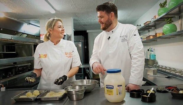 Chef Pieter Malan and a fellow chef preparing food with Hellmann’s mayonnaise in a professional kitchen.