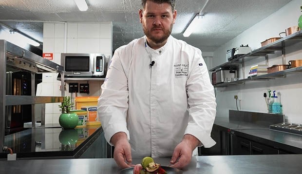 Chef Pieter Malan preparing a dish in a professional kitchen.