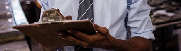 Person writing on clipboard.