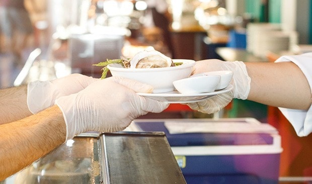 Server handing food over a counter. 