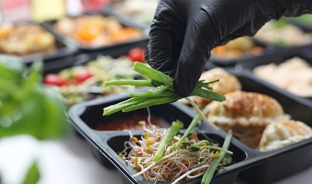 Chef  garnishing with gloves on.