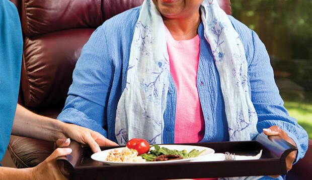 Woman holding plate of healthy food. 