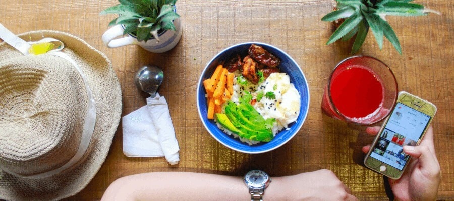 person taking photo of food salad bowl